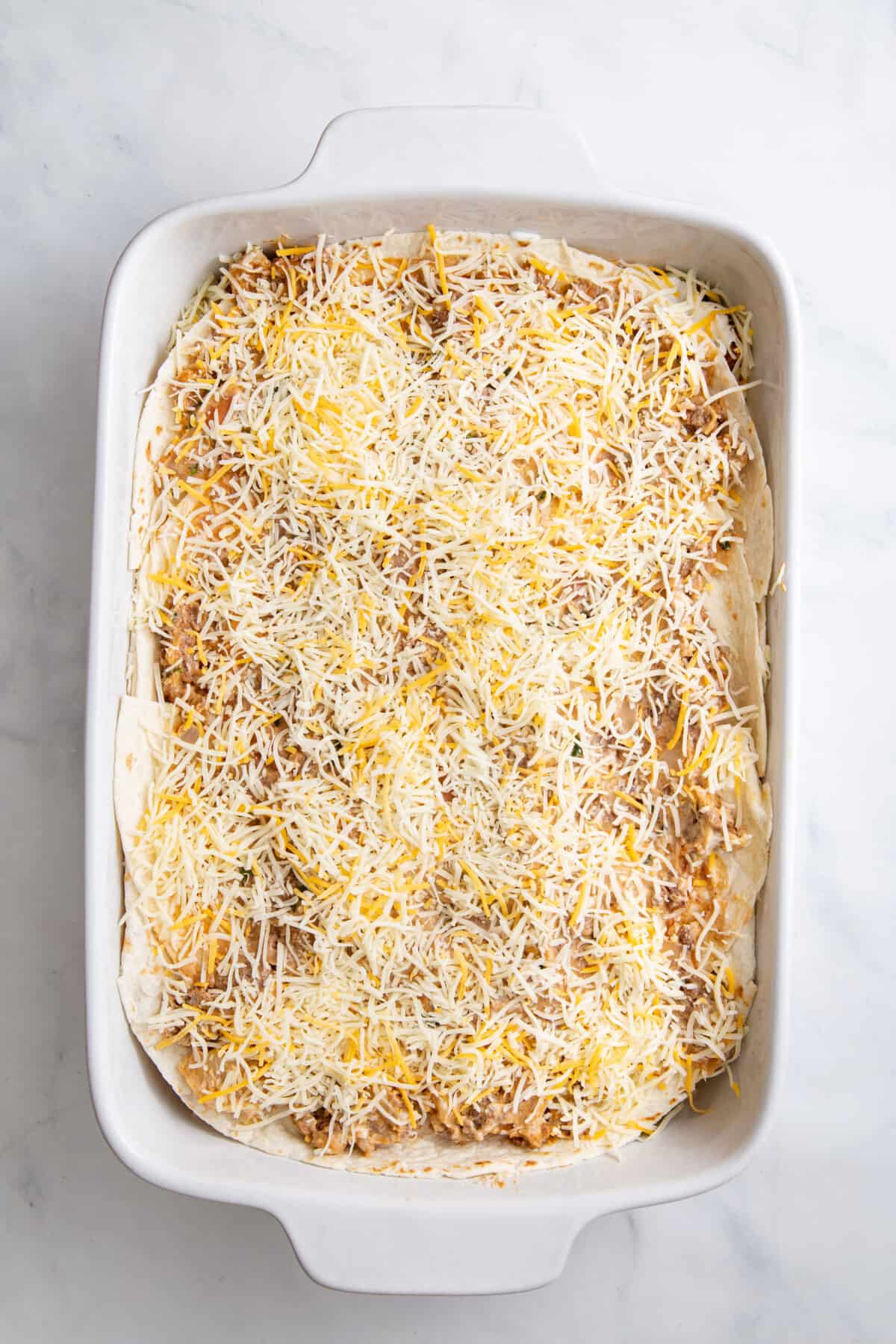 step 4 to make burrito casserole, repeat layer finishing with shredded cheese on top.