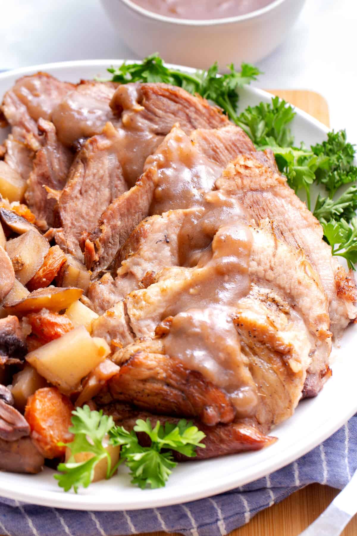 Instant Pot pork roast on a plate with veggies.