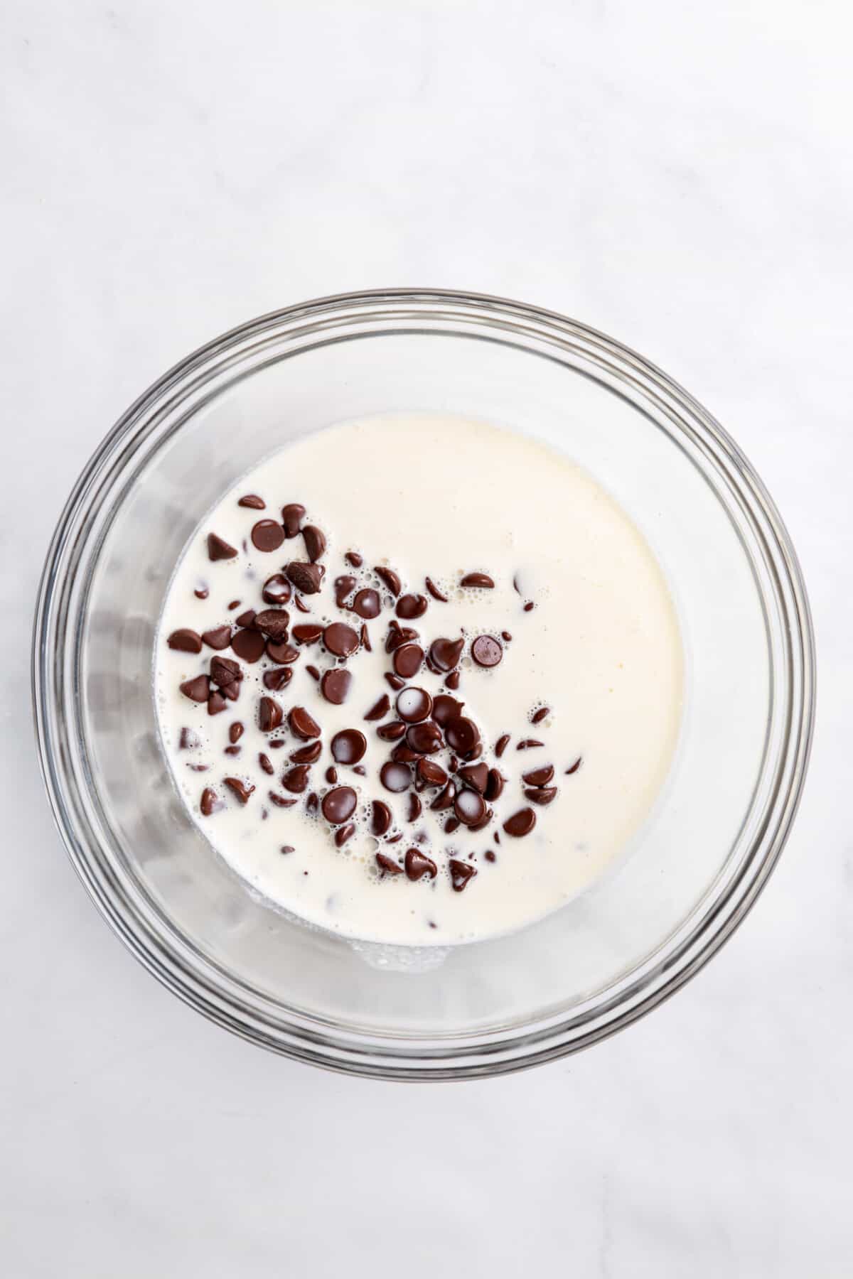step 1 to make s'mores dip, combine warm heavy cream and chocolate chips in a heat safe bowl.