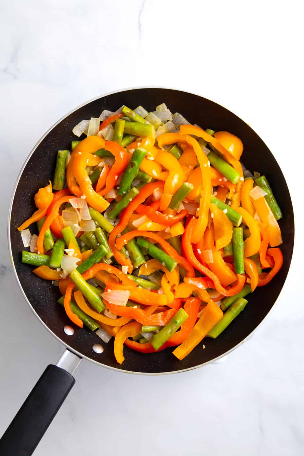 step 1 to make spicy chicken chipotle pasta, cook the fajita veggies.