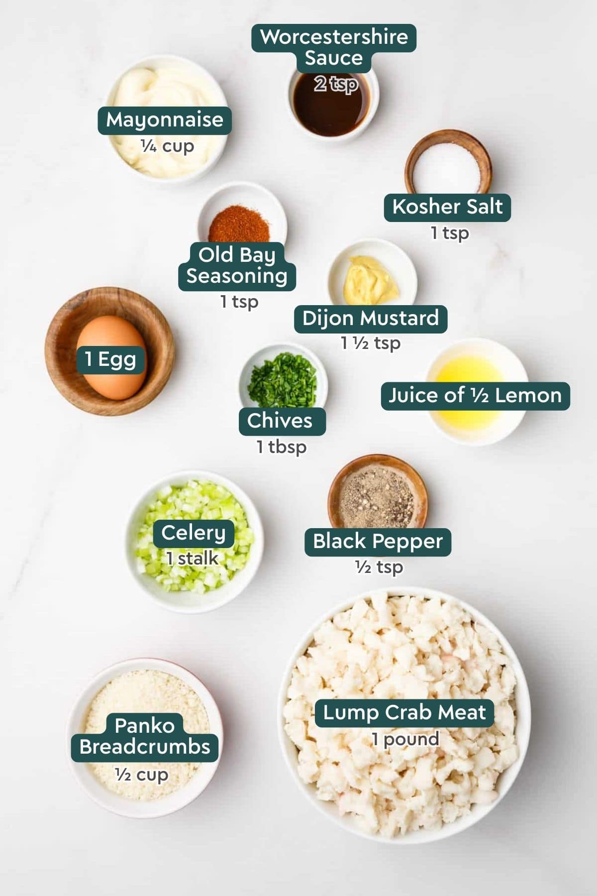 Ingredients for air fryer crab cakes, including mayo, worcestershire sauce, salt, old bay, dijon, lemon, chives, egg, black pepper, celery, crab, panko.
