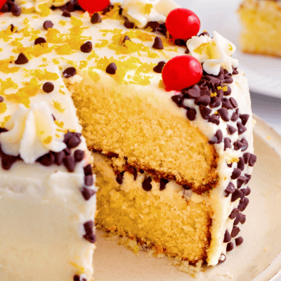 A layered cannoli cake with a slice missing.