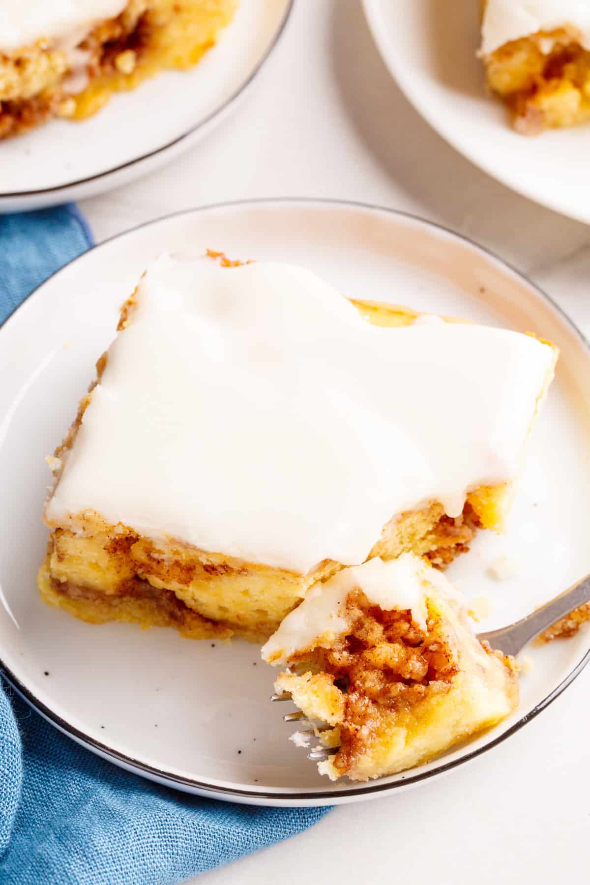 sqaure slice of cinnamon roll cake served on a white round plate