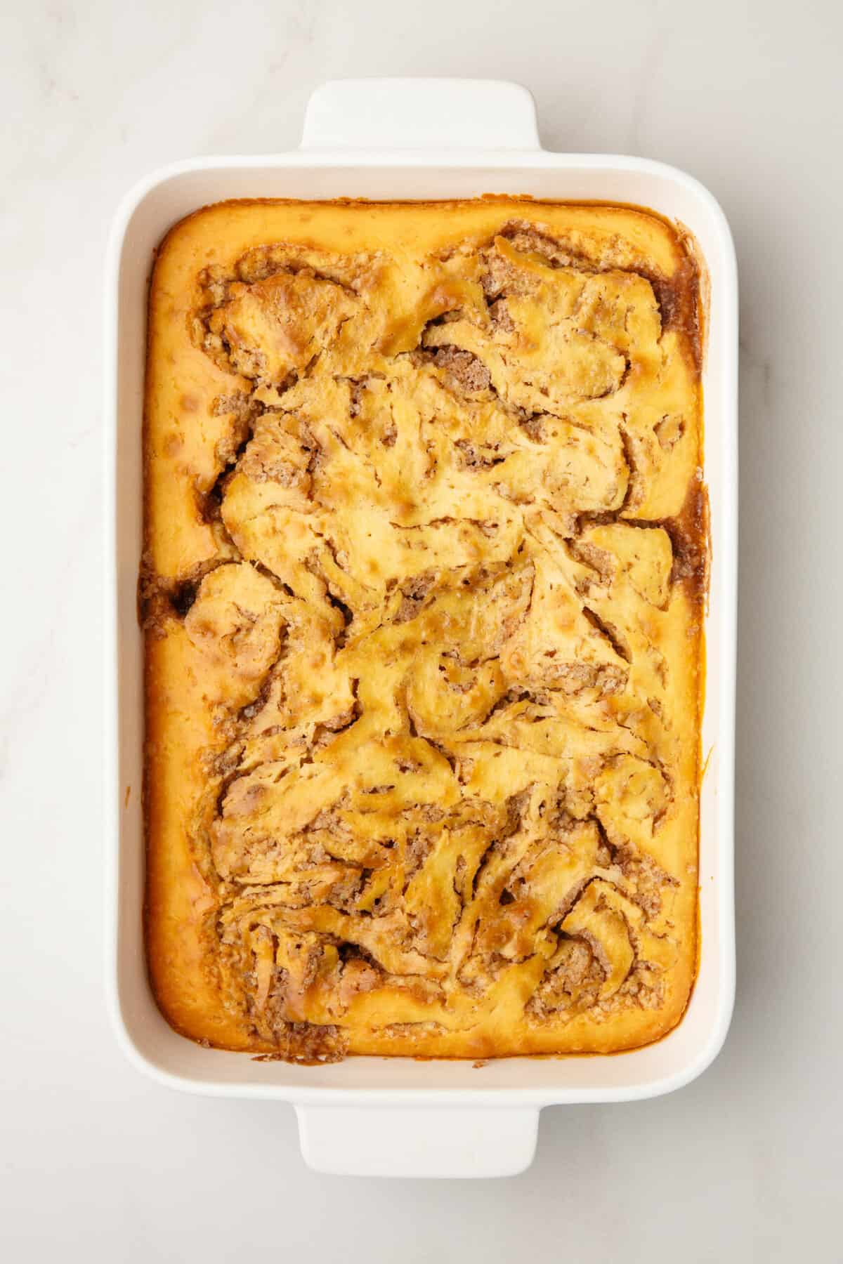 baked cinnamon roll cake sitting in a 9x13 casserole dish