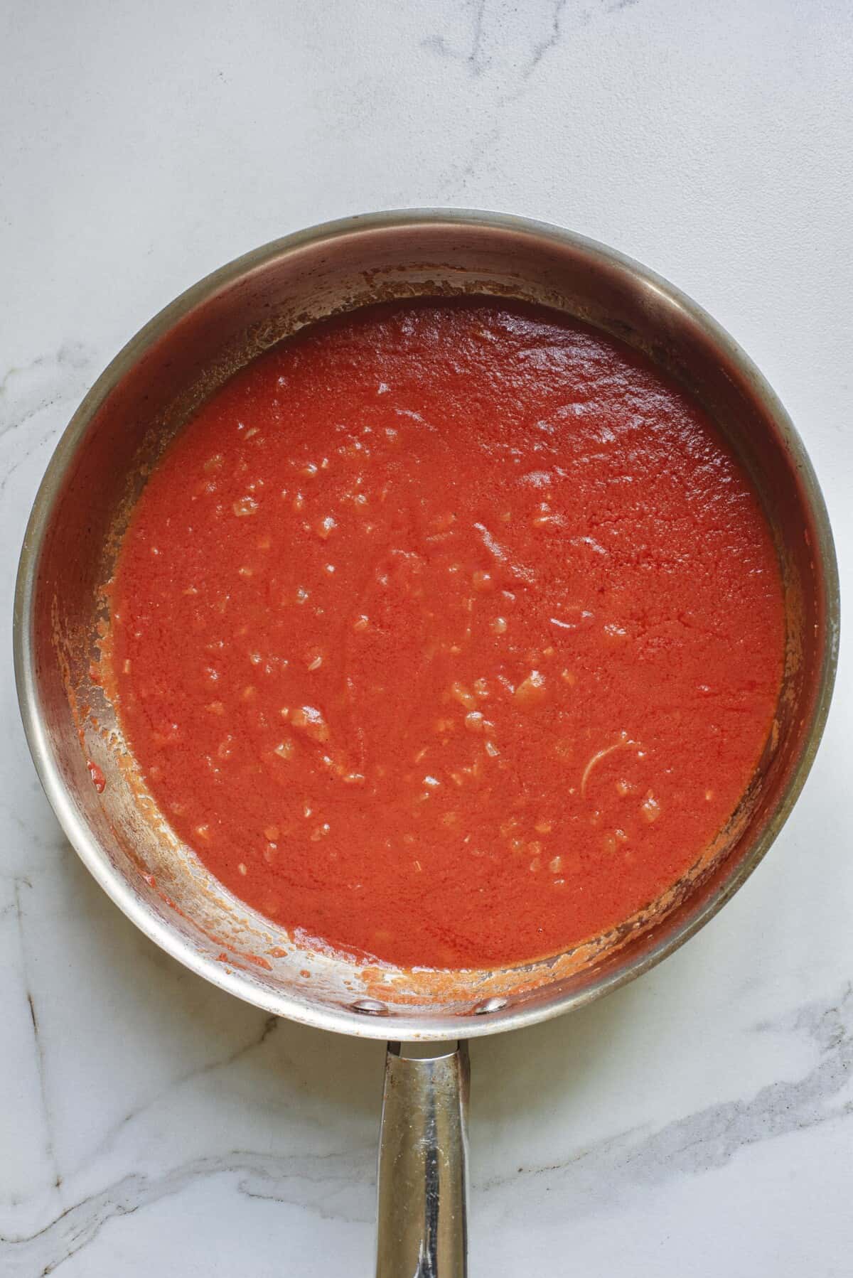 step 2 to make creamy tomato pasta, add jarred tomato sauce to the pan.