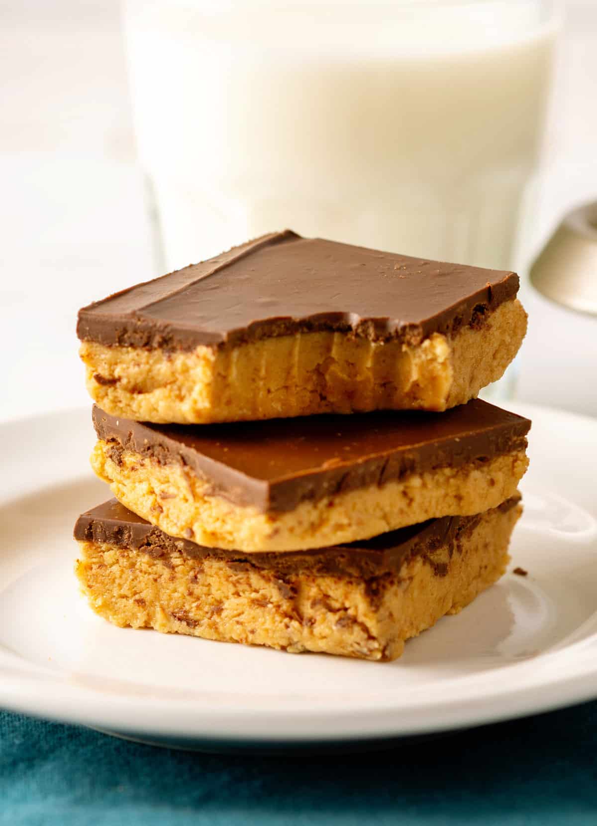 stack of three no bake peanut butter bars sitting on a white round plate