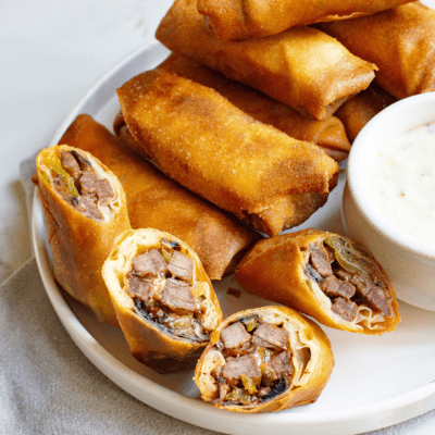 Philly cheesesteak egg rolls on a plate.