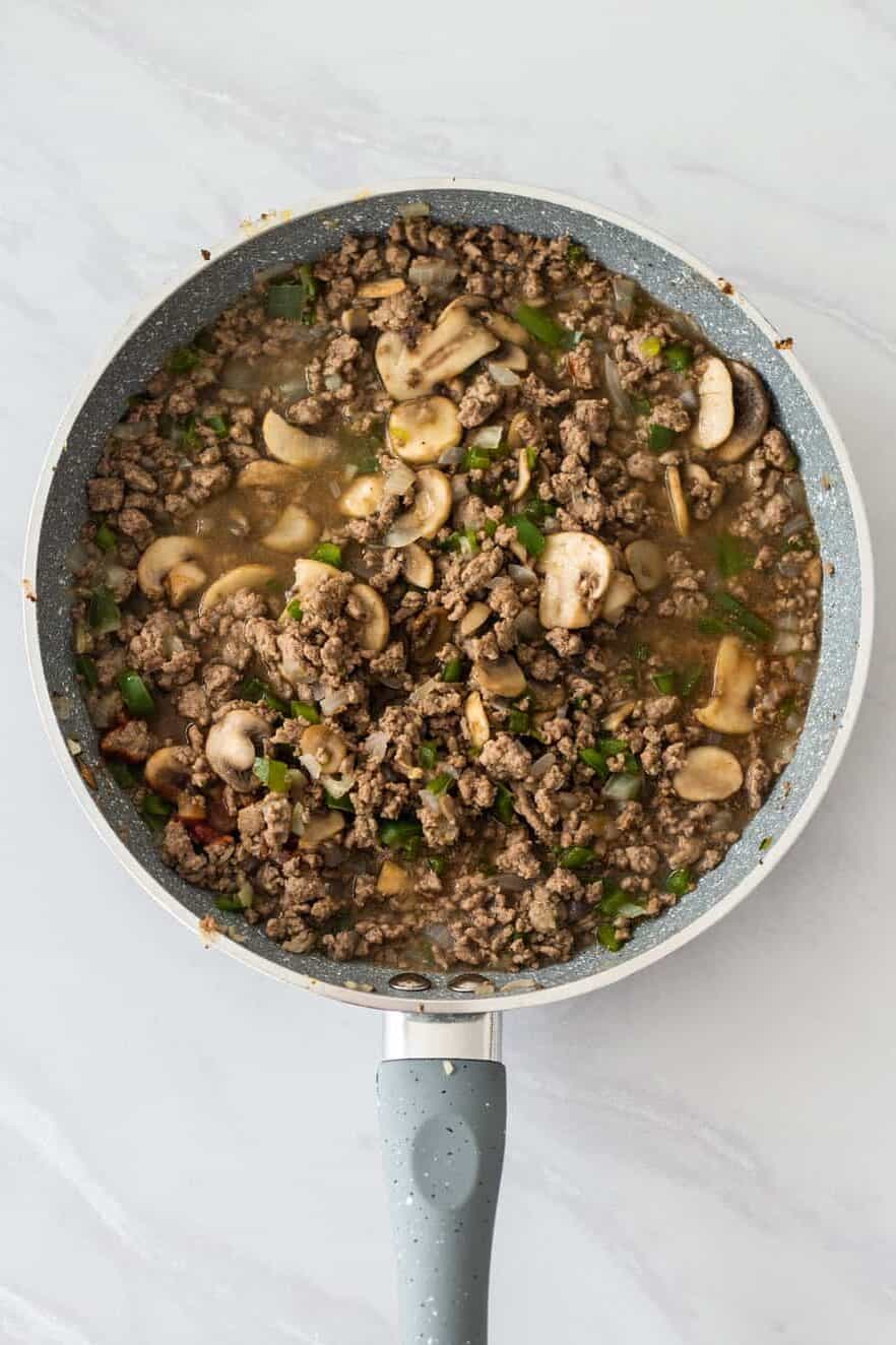 step 2 to make Philly cheesesteak sloppy joes, add veggies to ground beef in the pan