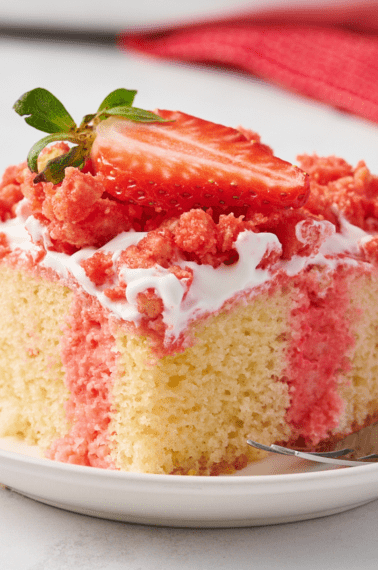 A slice of strawberry crunch poke cake on a plate.