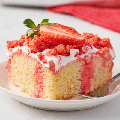 A slice of strawberry crunch poke cake on a plate.