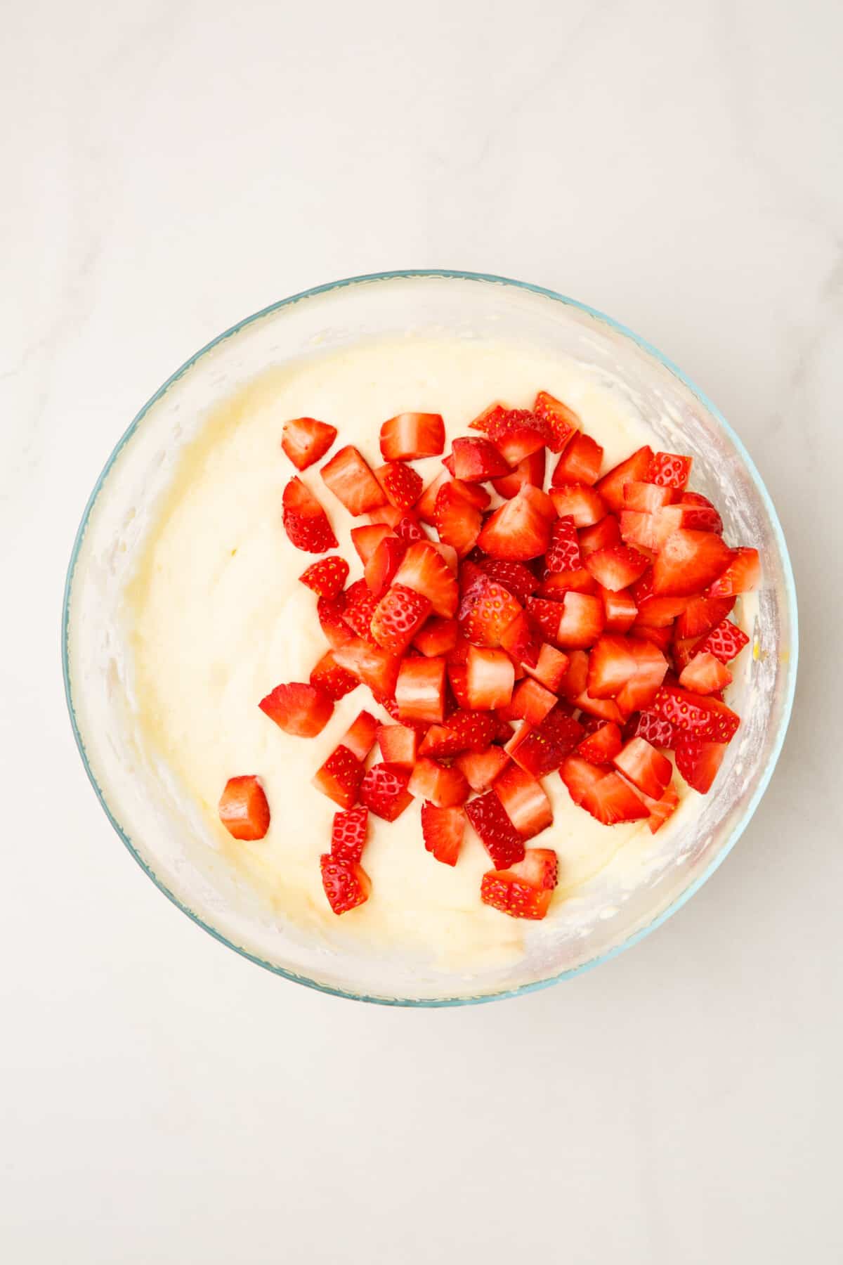 step 3 to make strawberry pancakes, add fresh cut strawberries to the large glass bowl of pancake batter.