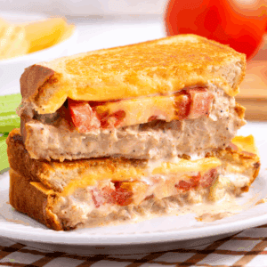 Two halves of a tuna melt sandwich stacked on top of each other.