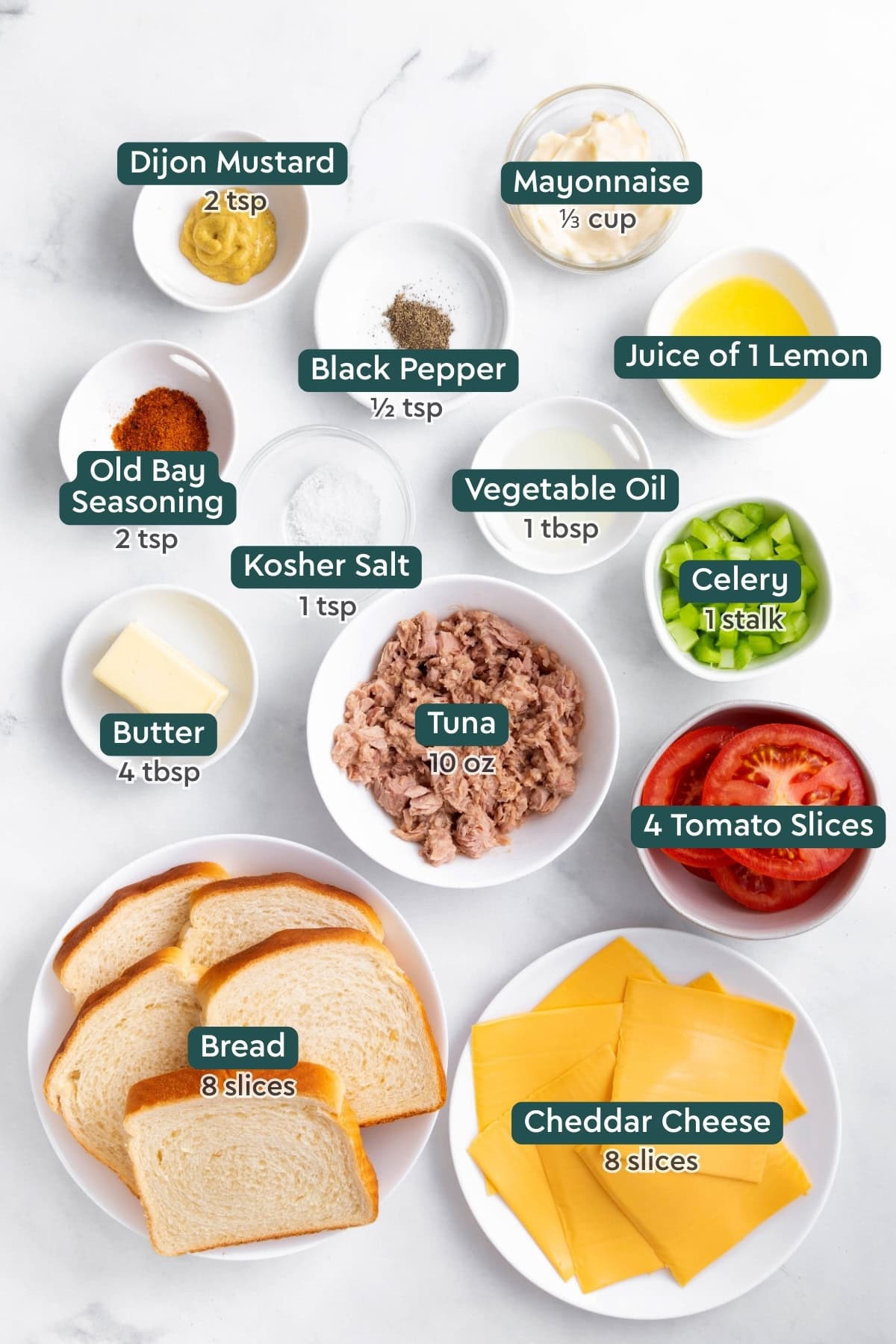 Ingredients for tuna melt sandwich, including mayo, mustard, lemon juice, seasonings, celery, tuna, butter, tomato, cheese, and bread.