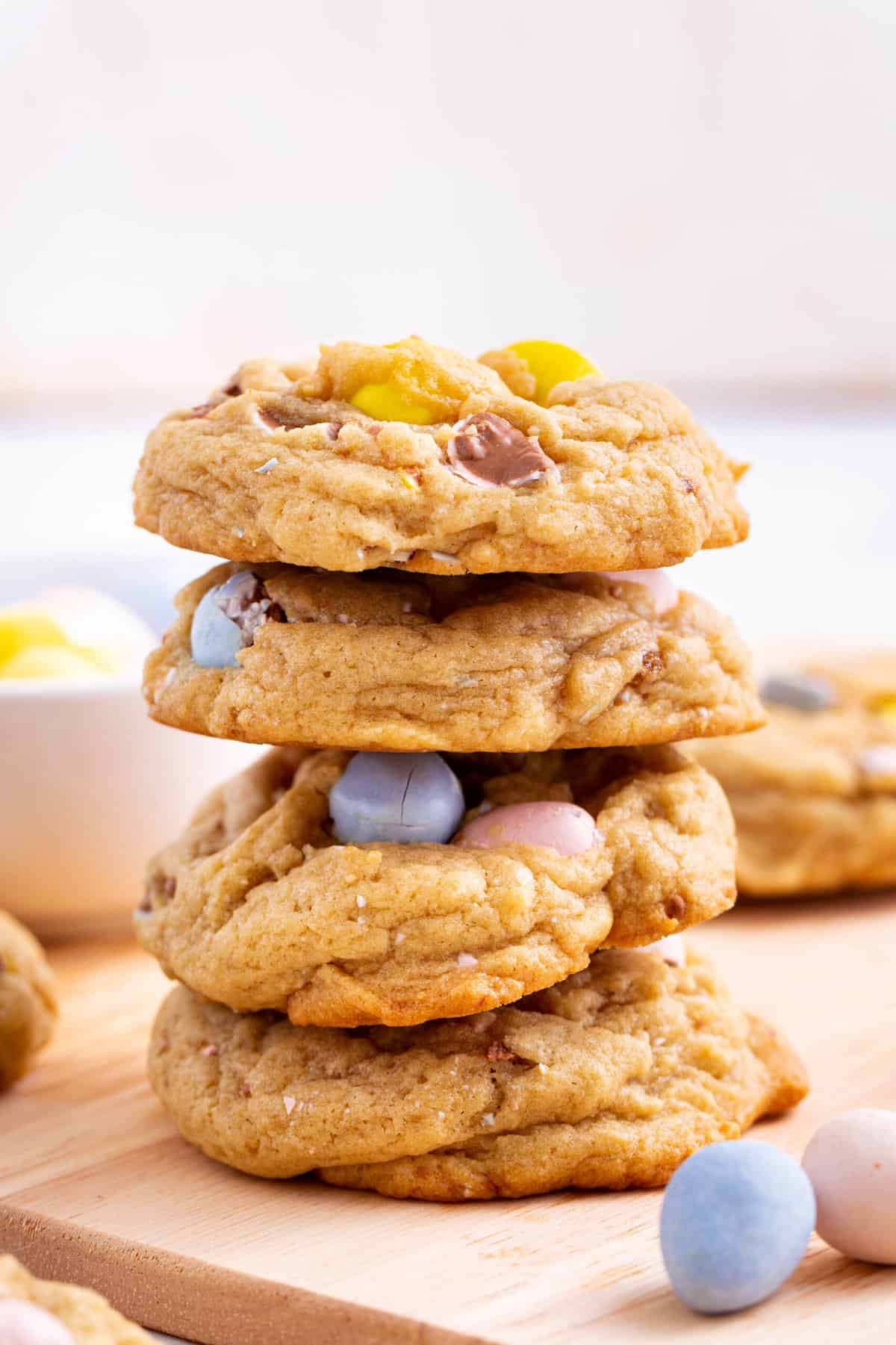 stacks of four cadbury egg cookies sitting on a wood board