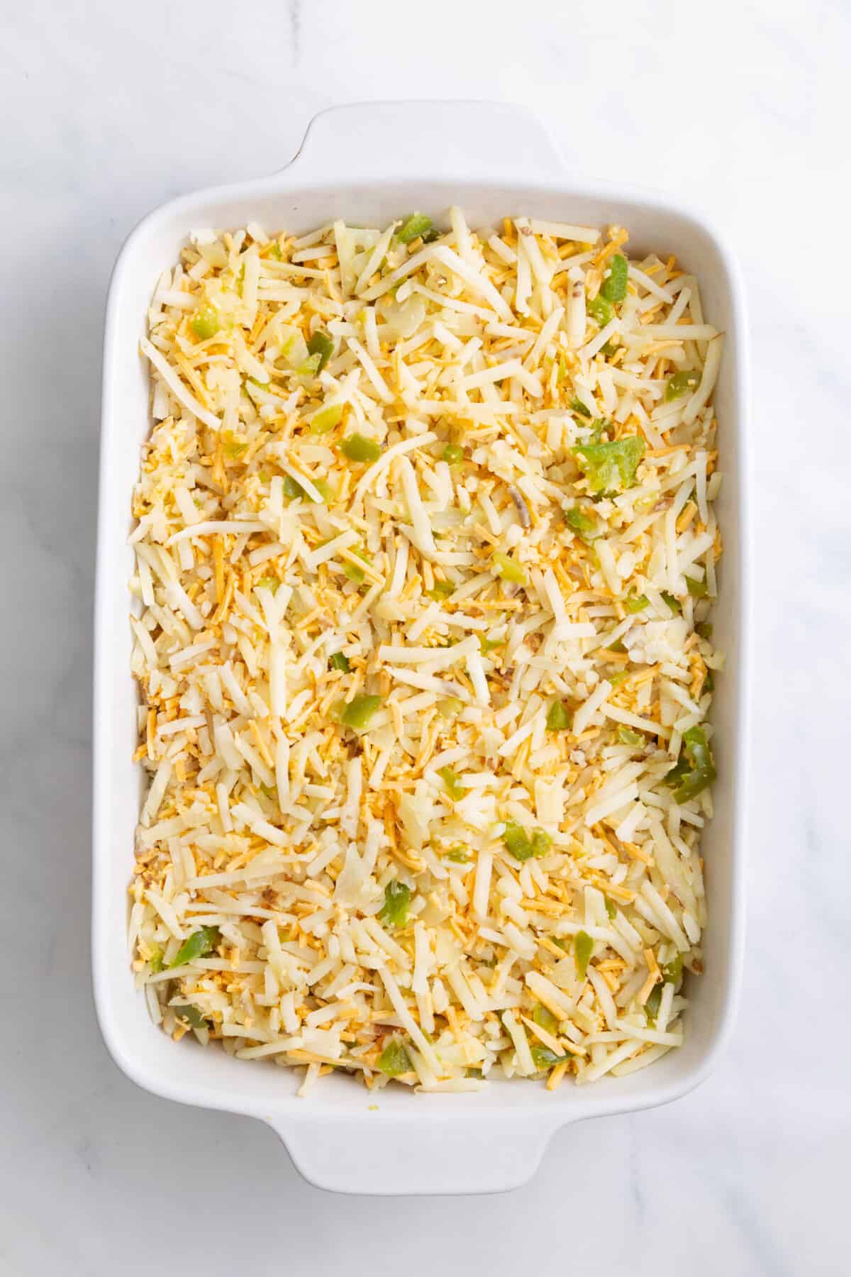 step 2 to make cheesy breakfast potato casserole, layer mixture and shredded cheese into a 9x12 inch casserole dish.