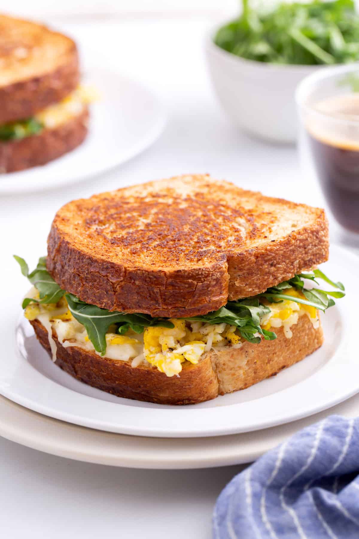 one scrambled egg sandwich served on a white round plate