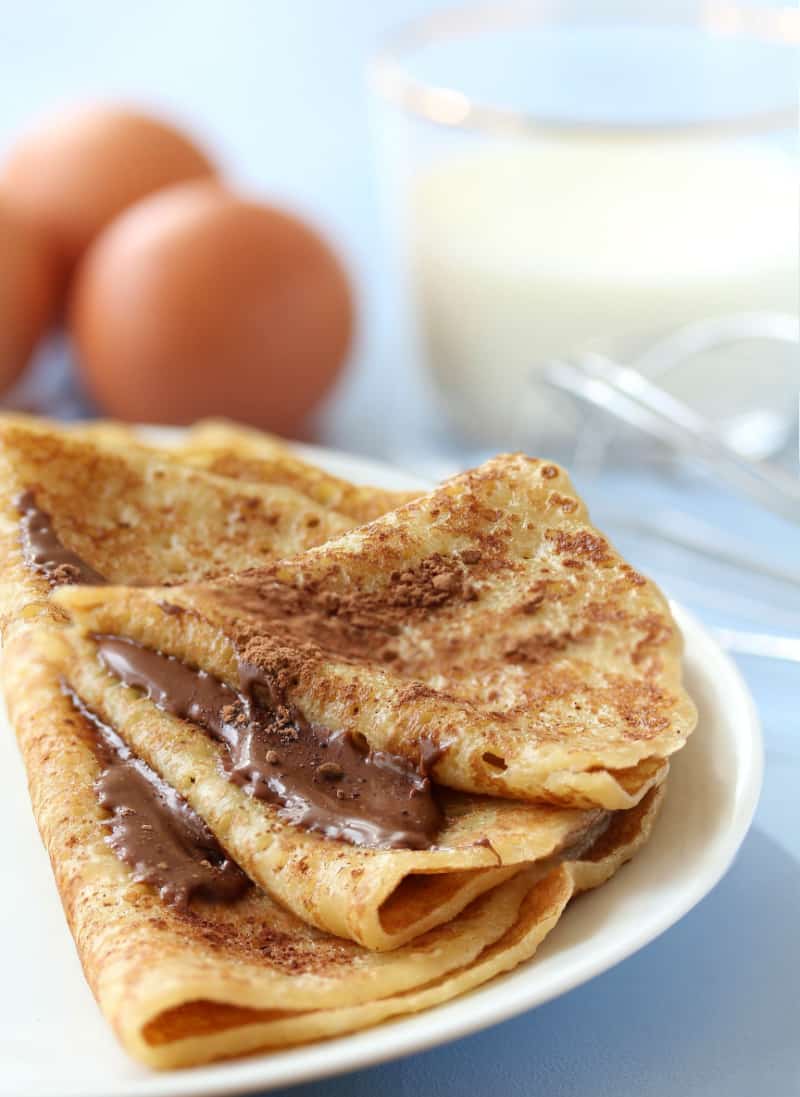 nutella filled crepes served on a white round plate