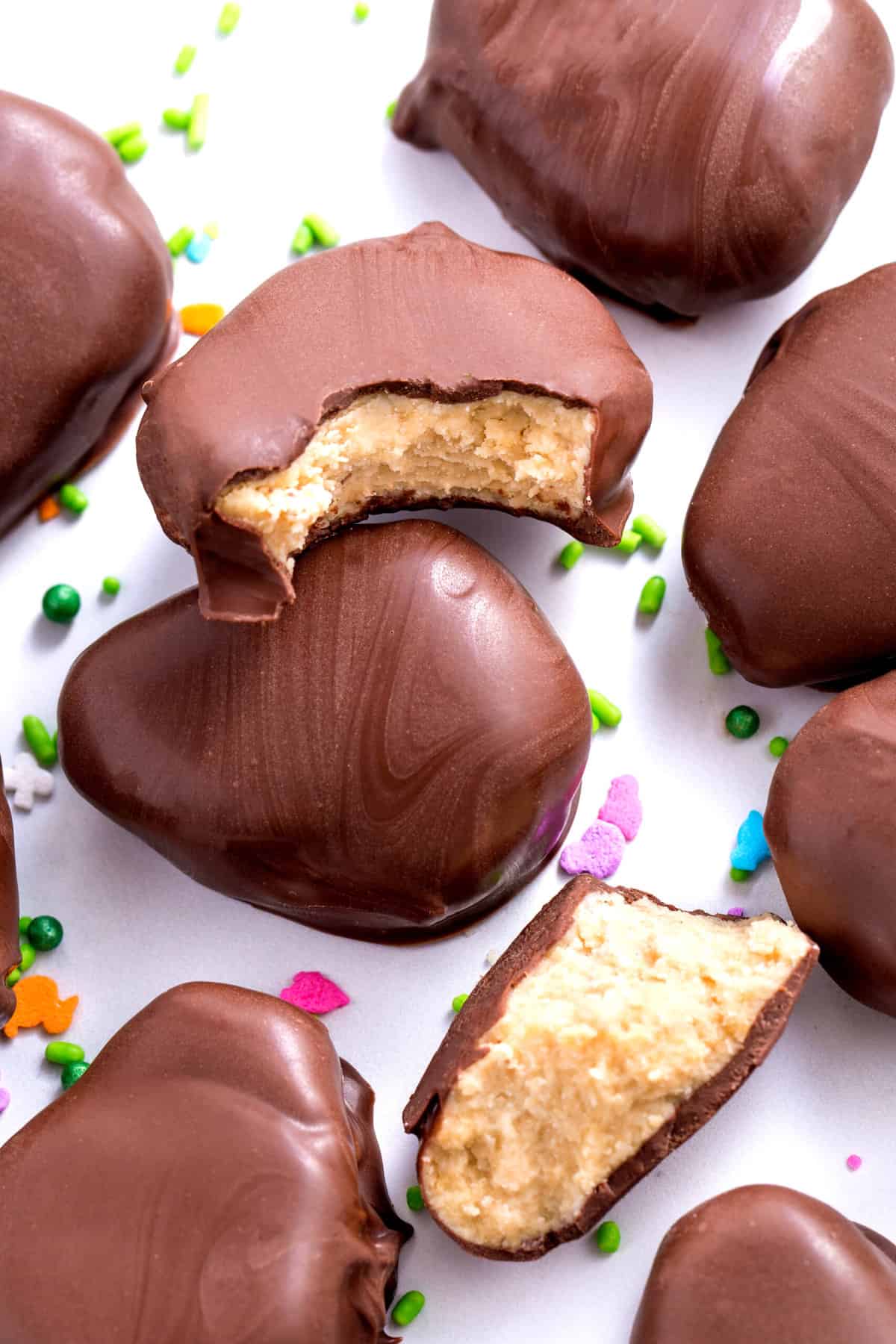 several homemade chocolate peanut butter eggs with sprinkles on the table for decoration.