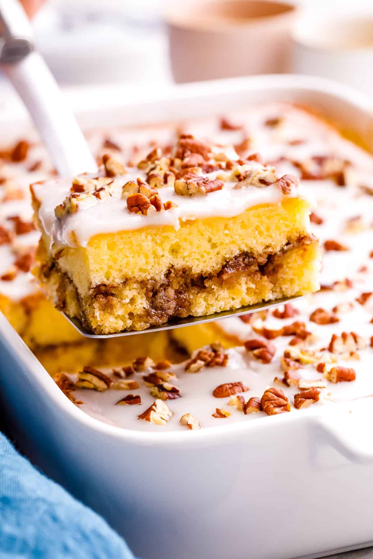 A slice of honey bun cake being lifted from a dish.