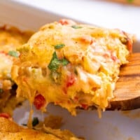 A serving of King Ranch chicken casserole being lifted from a baking dish.