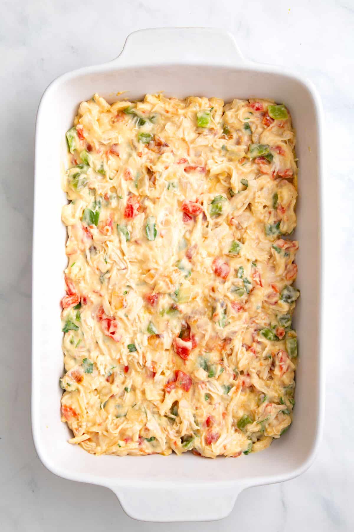 step 2 to make king ranch chicken casserole, layer chicken mixture over tortillas in a casserole baking dish.