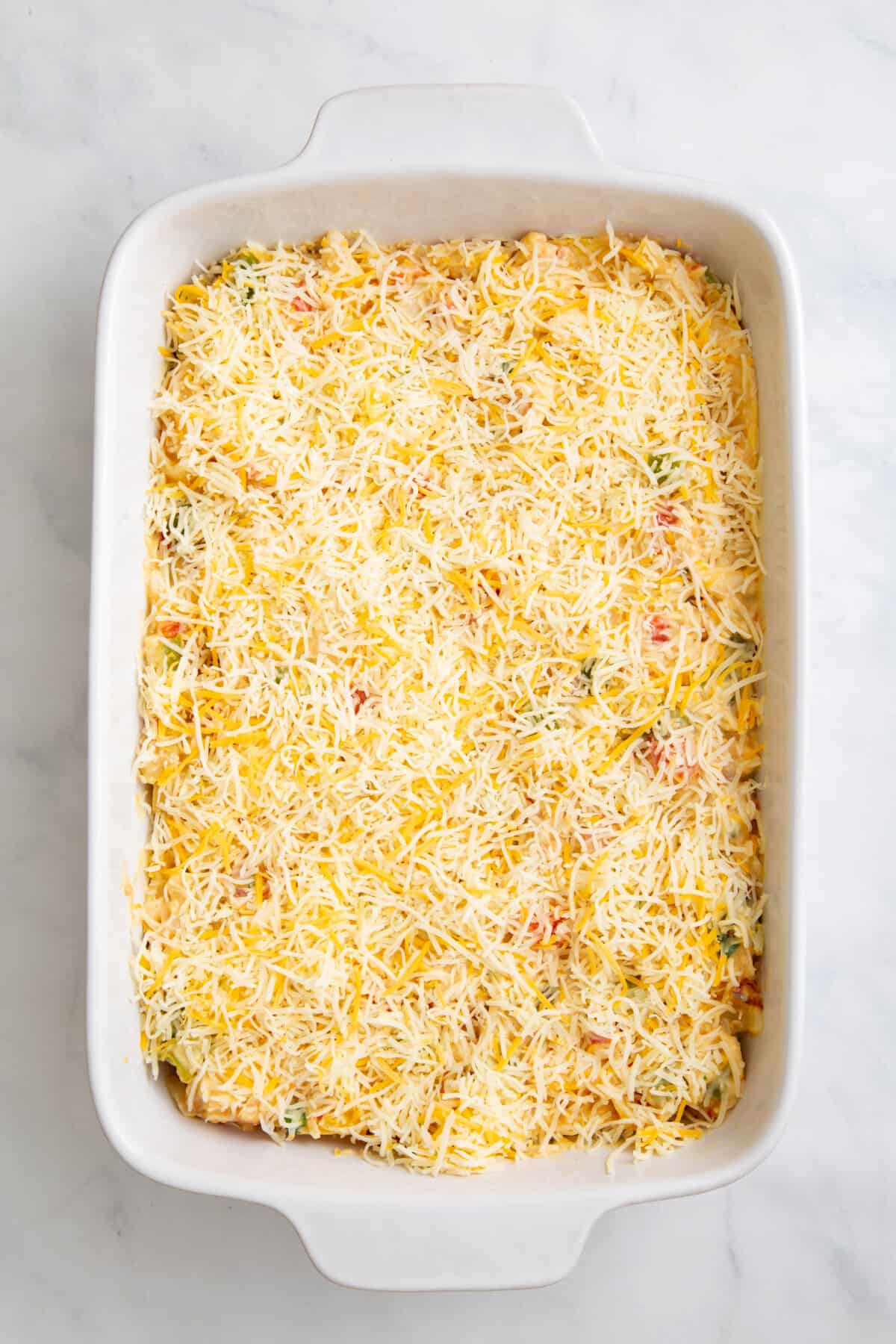 step 4 to make king ranch chicken casserole, top casserole with shredded mexican cheese.
