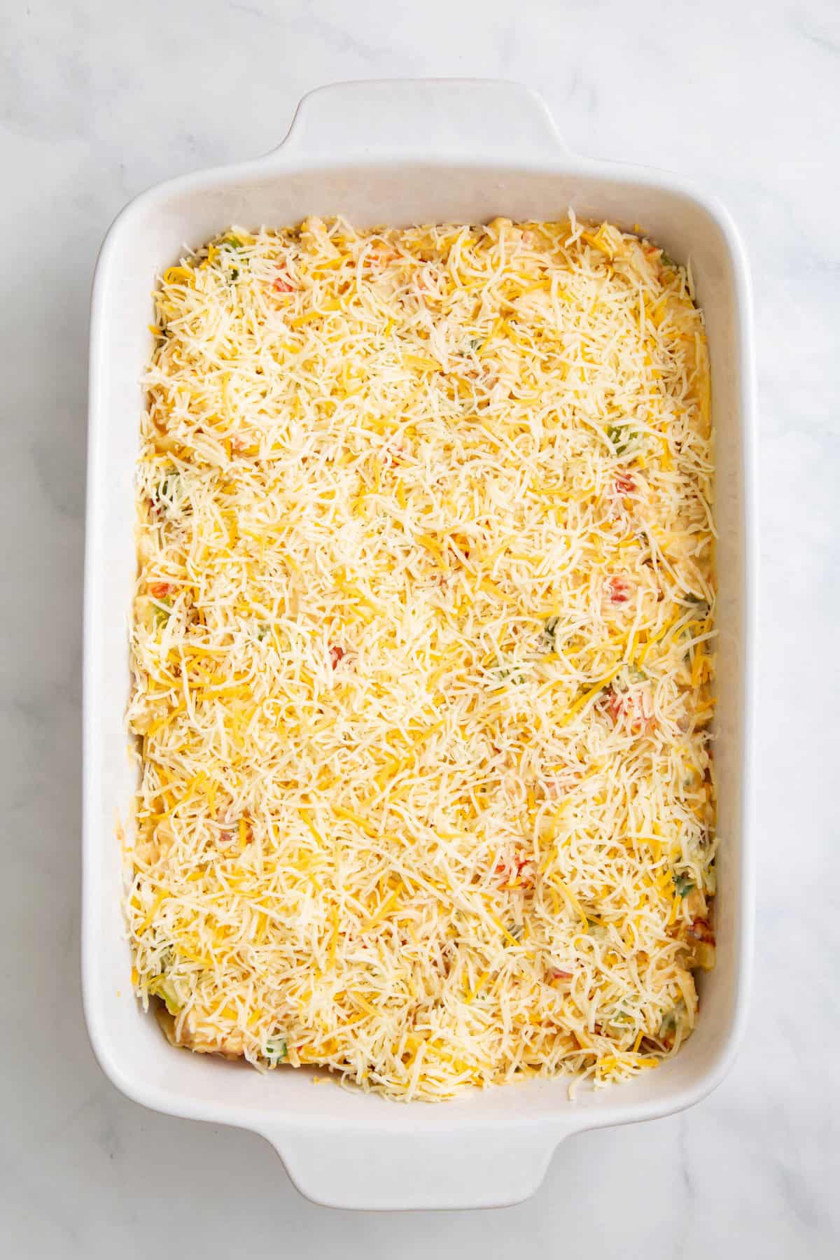 step 4 to make king ranch chicken casserole, top casserole with shredded mexican cheese