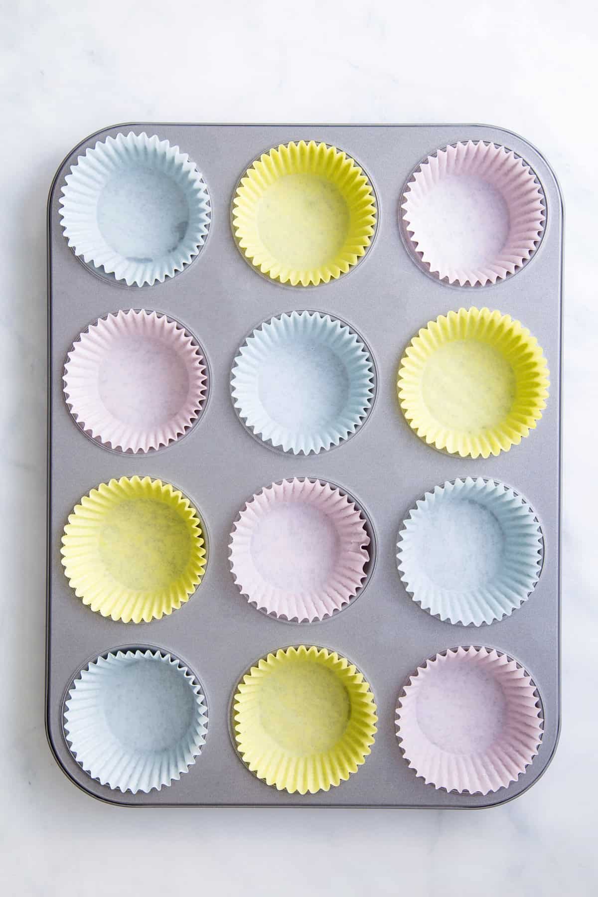 12 muffin tin lined with pastel colored liners