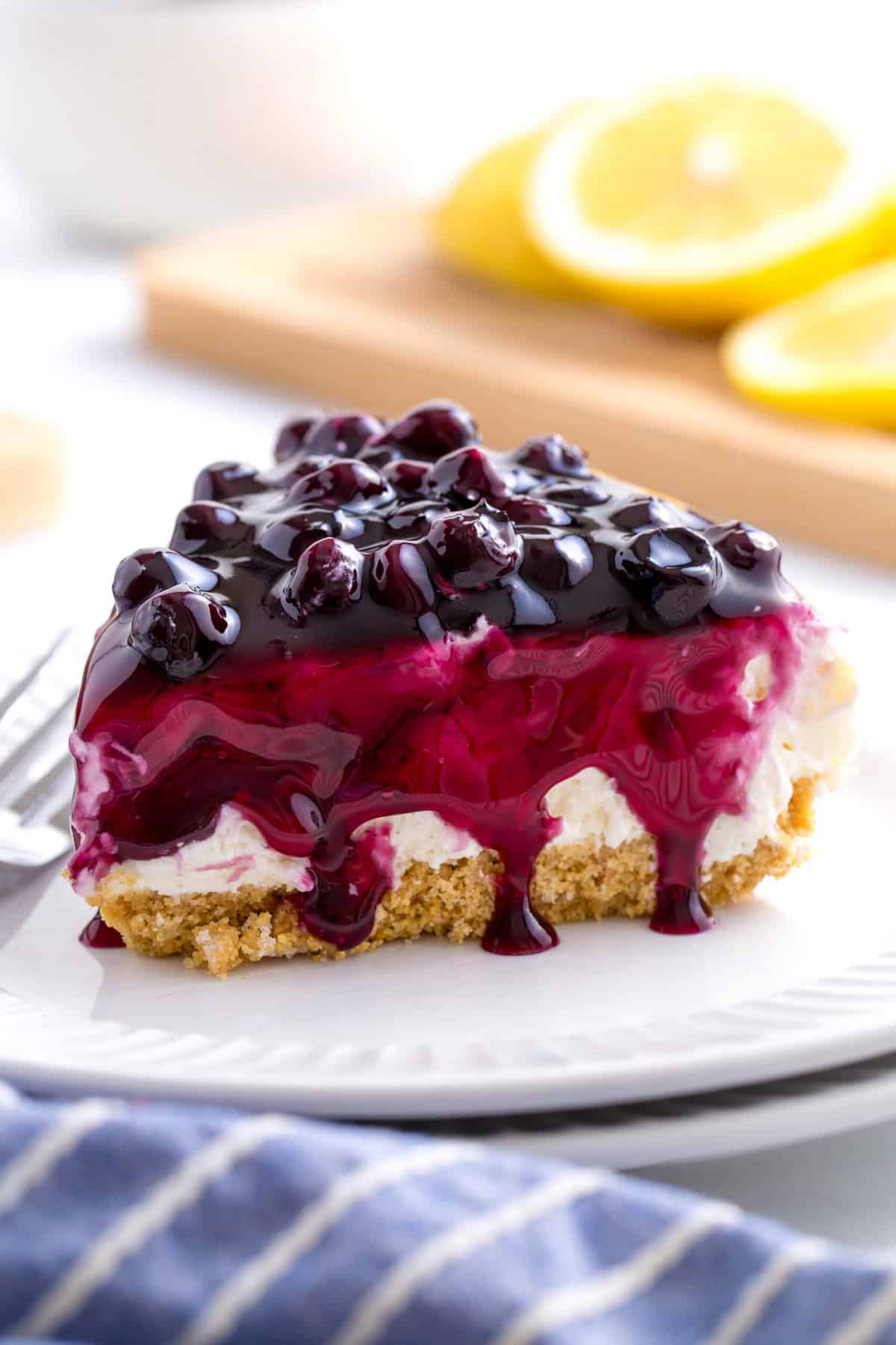 Slice of no-bake blueberry cheesecake served on a white round plate