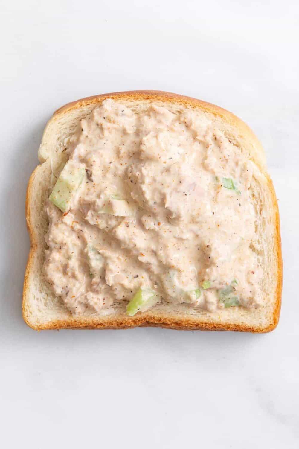 step 1 to make a tuna melt sandwich, place tuna salad on a piece of white toast