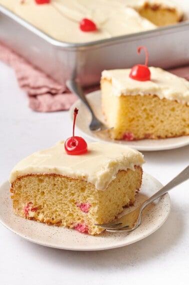 Slices of frosted cherry cake on plates.