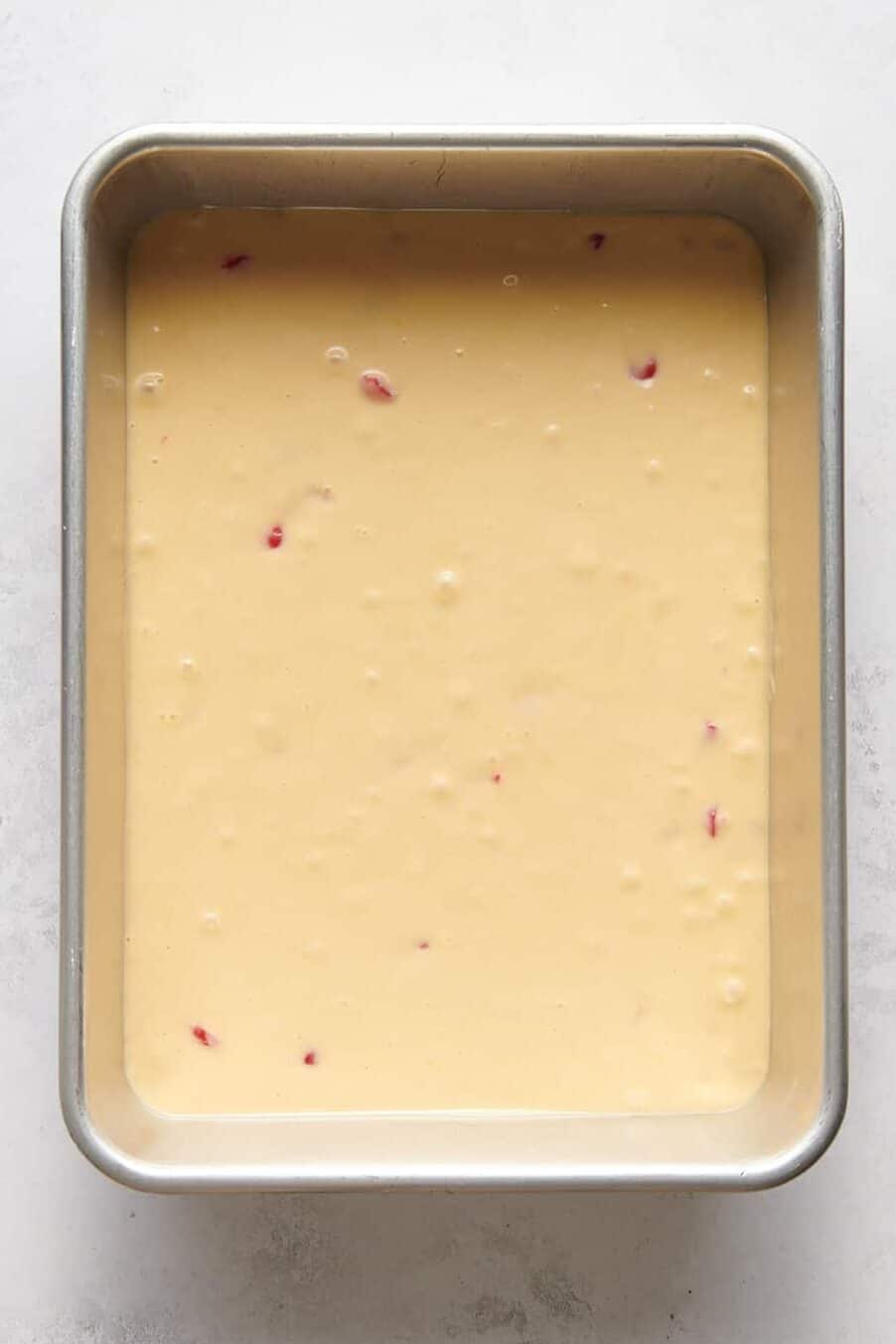 cherry cake batter in a 9x13 baking dish