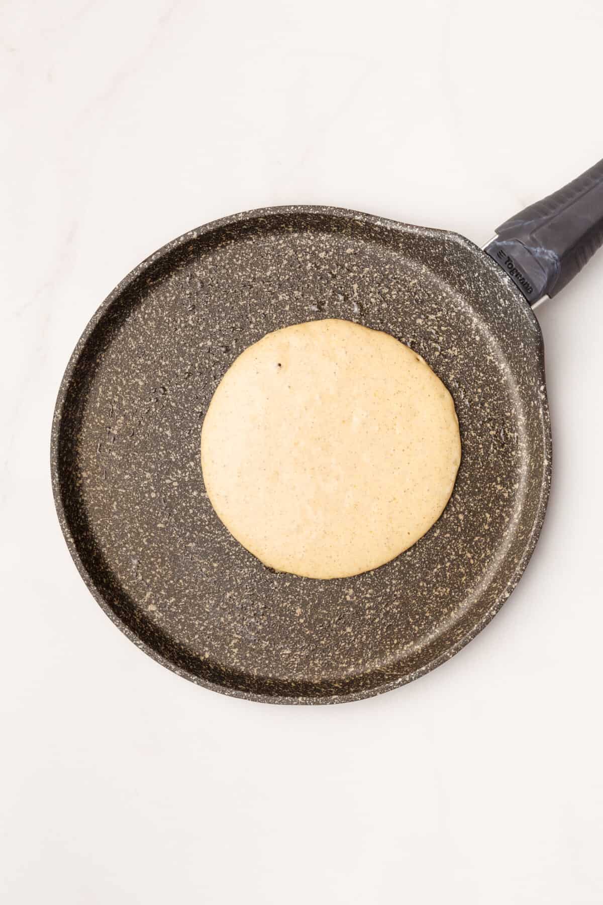 cinnamon pancake cooking on a skillet.