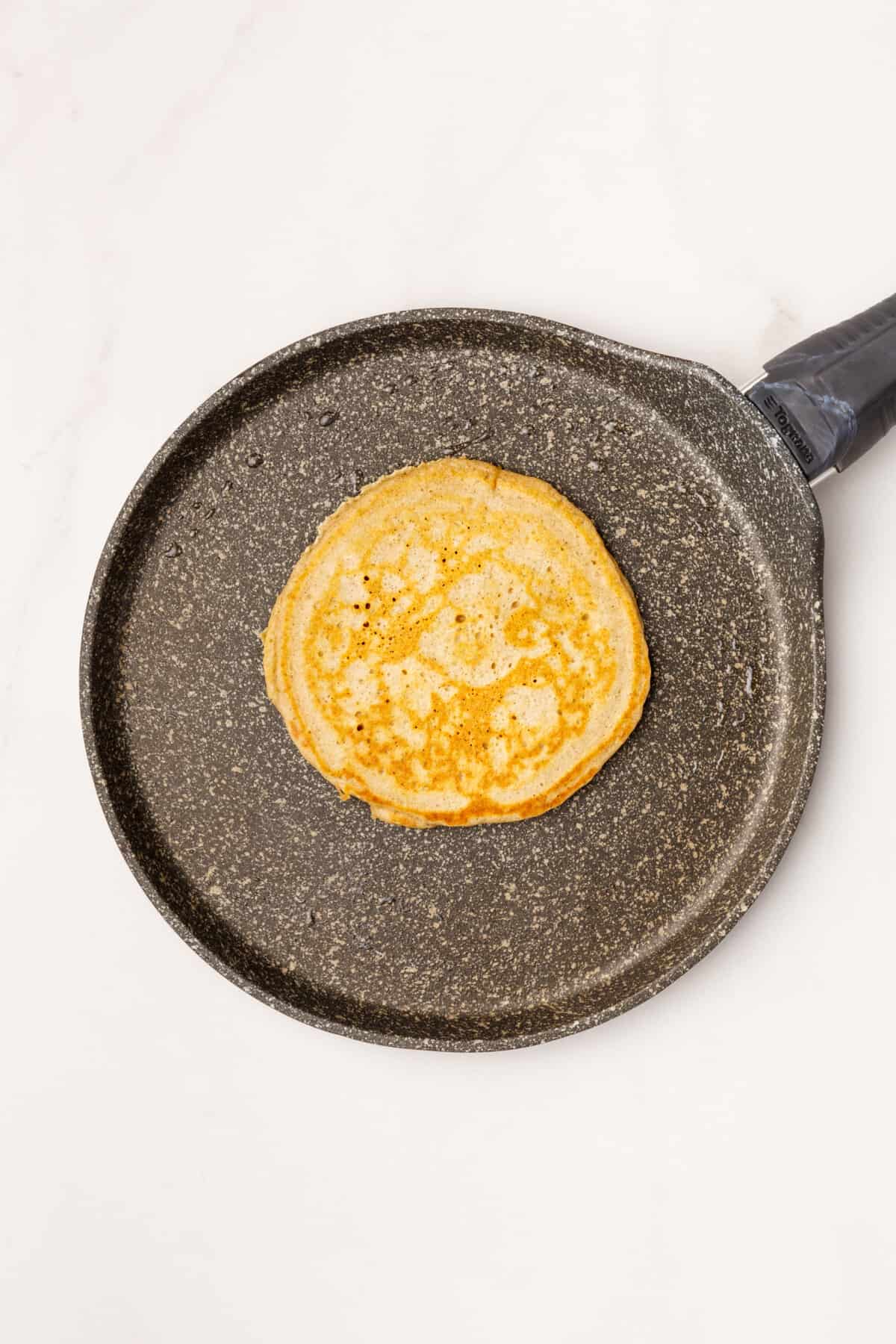 cinnamon pancake cooking on a skillet.