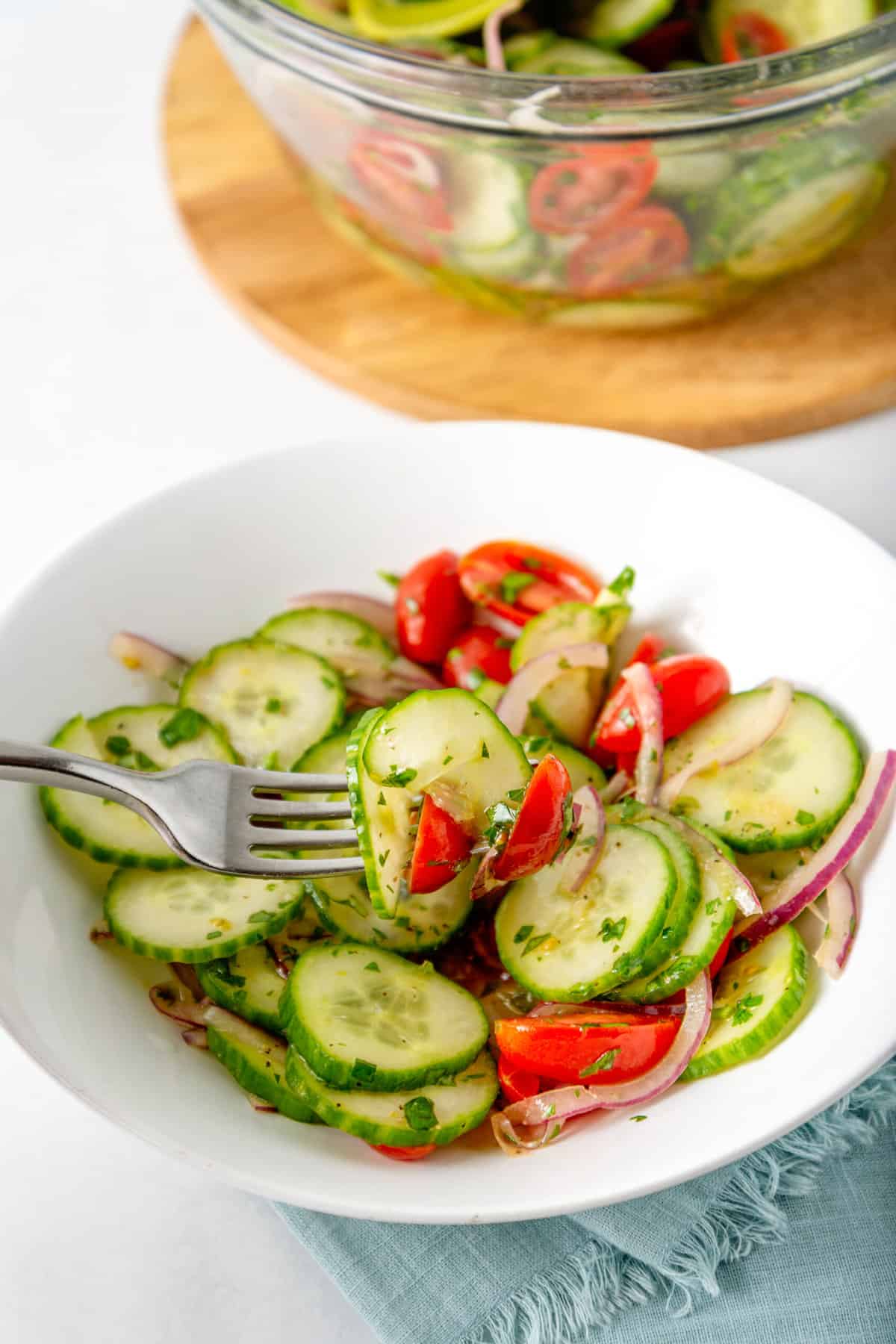 close up image of a forkful of cucumber tomato salad