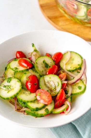 A bowl of cucumber and tomato salad.