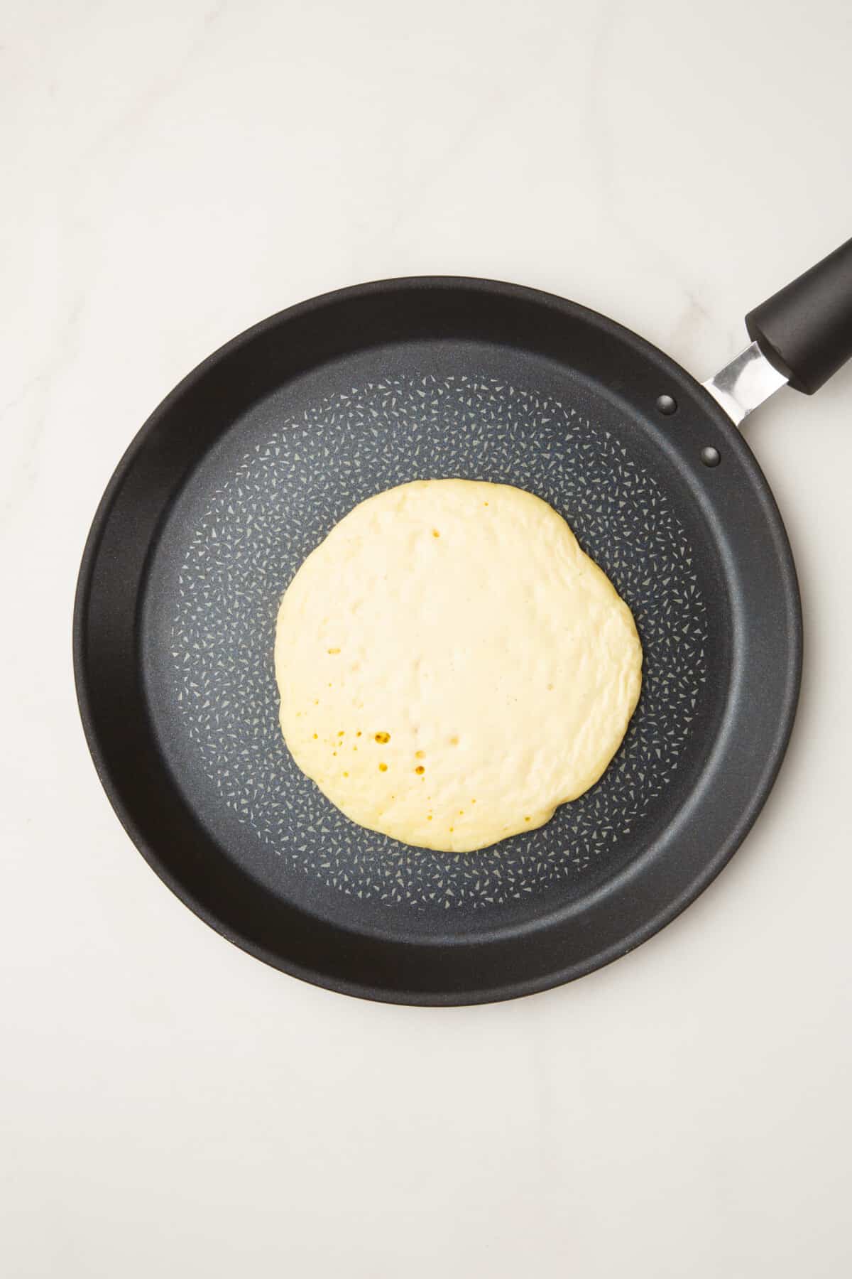 pancake ladled onto a pan.
