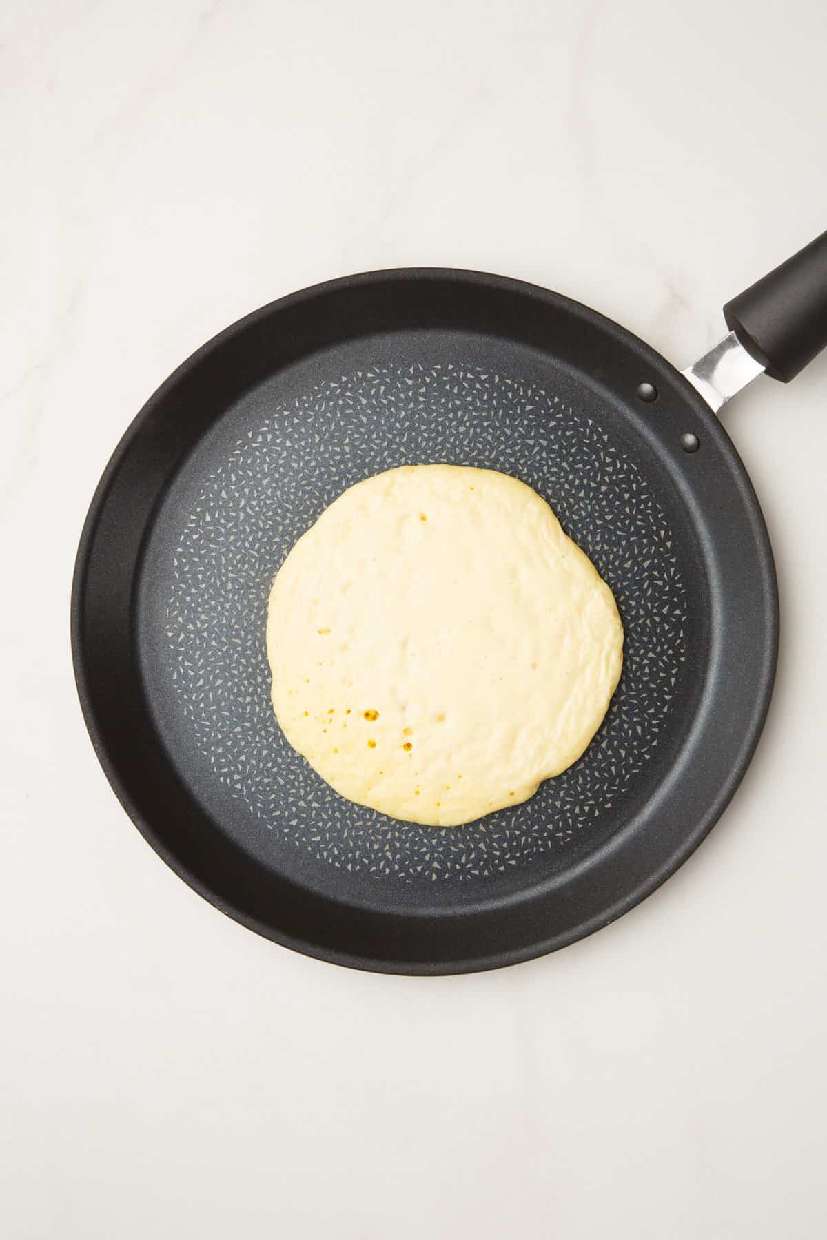 pancake ladled onto a pan
