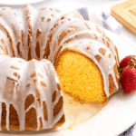 Pound cake topped with a glaze with a slice missing.