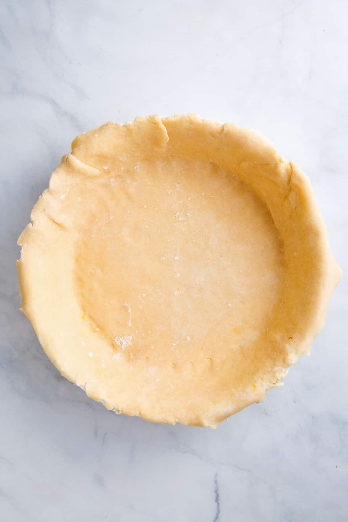 top down image of prepared and unbaked pie crust on a pie dish.