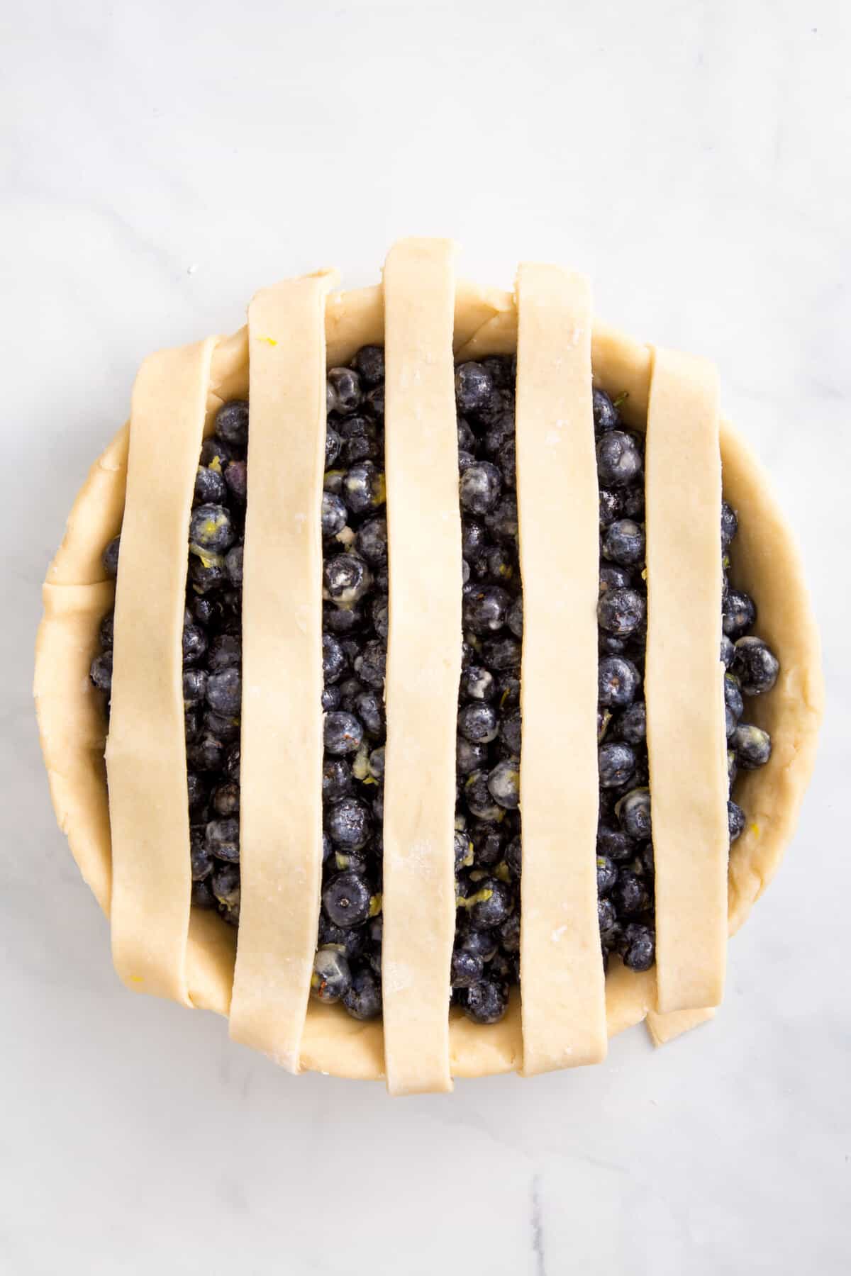 vertical pie dough design on a blueberry pie.