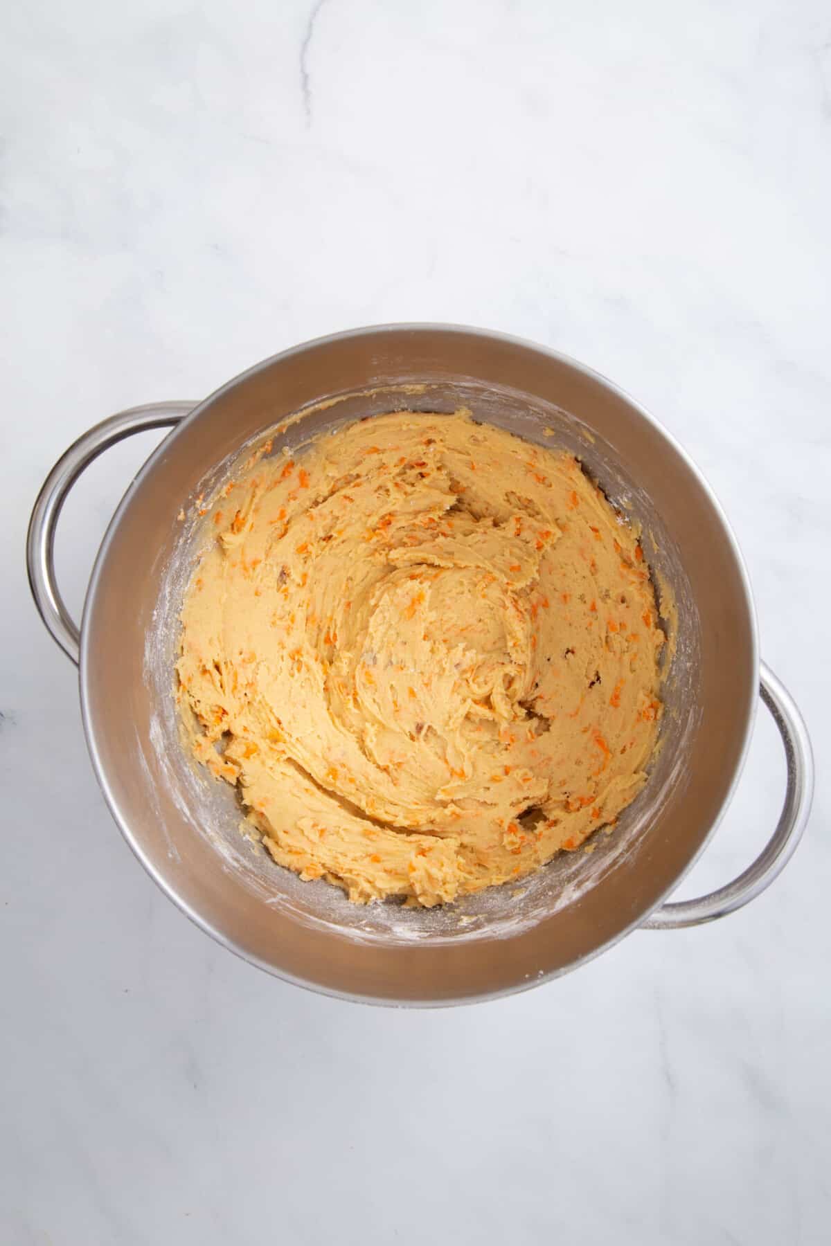 carrot cake cookie batter in a stainless steel mixer.