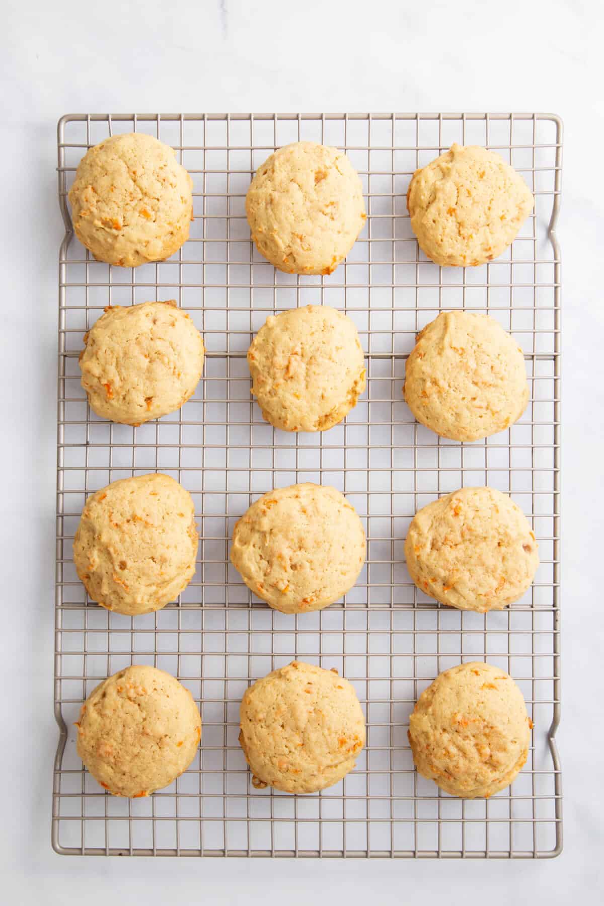 12 carrot cake cookies cooling on a wire rack.