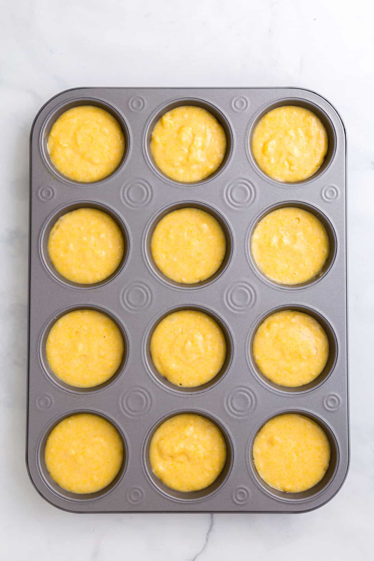 corn muffin batter in a 12 count muffin tin.