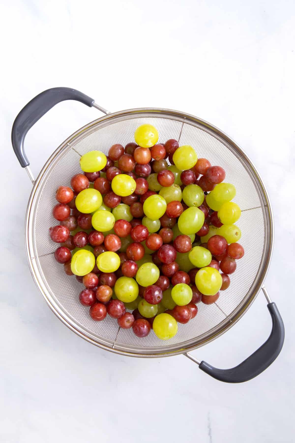 colander with red and green grapes