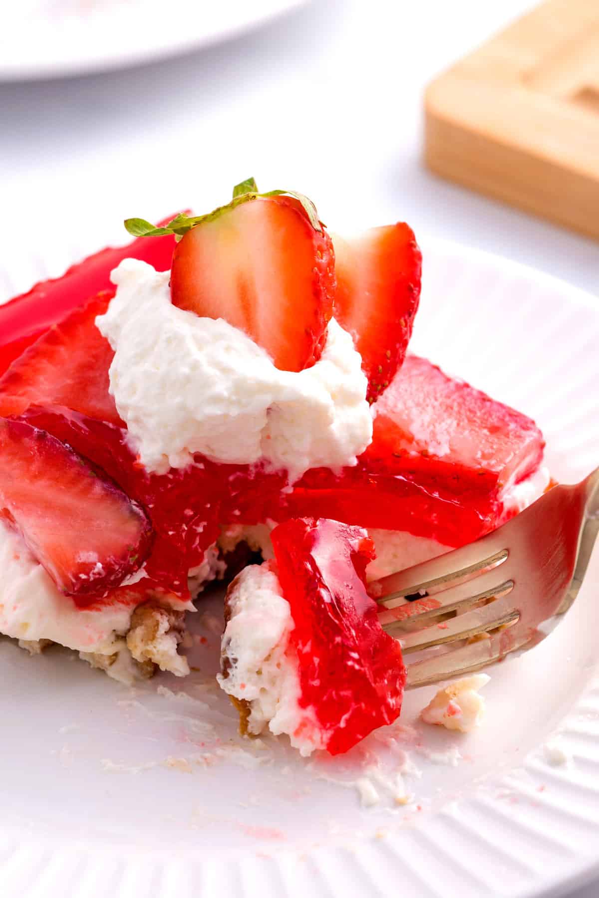 close up image of jello pretzel salad served on a white round plate