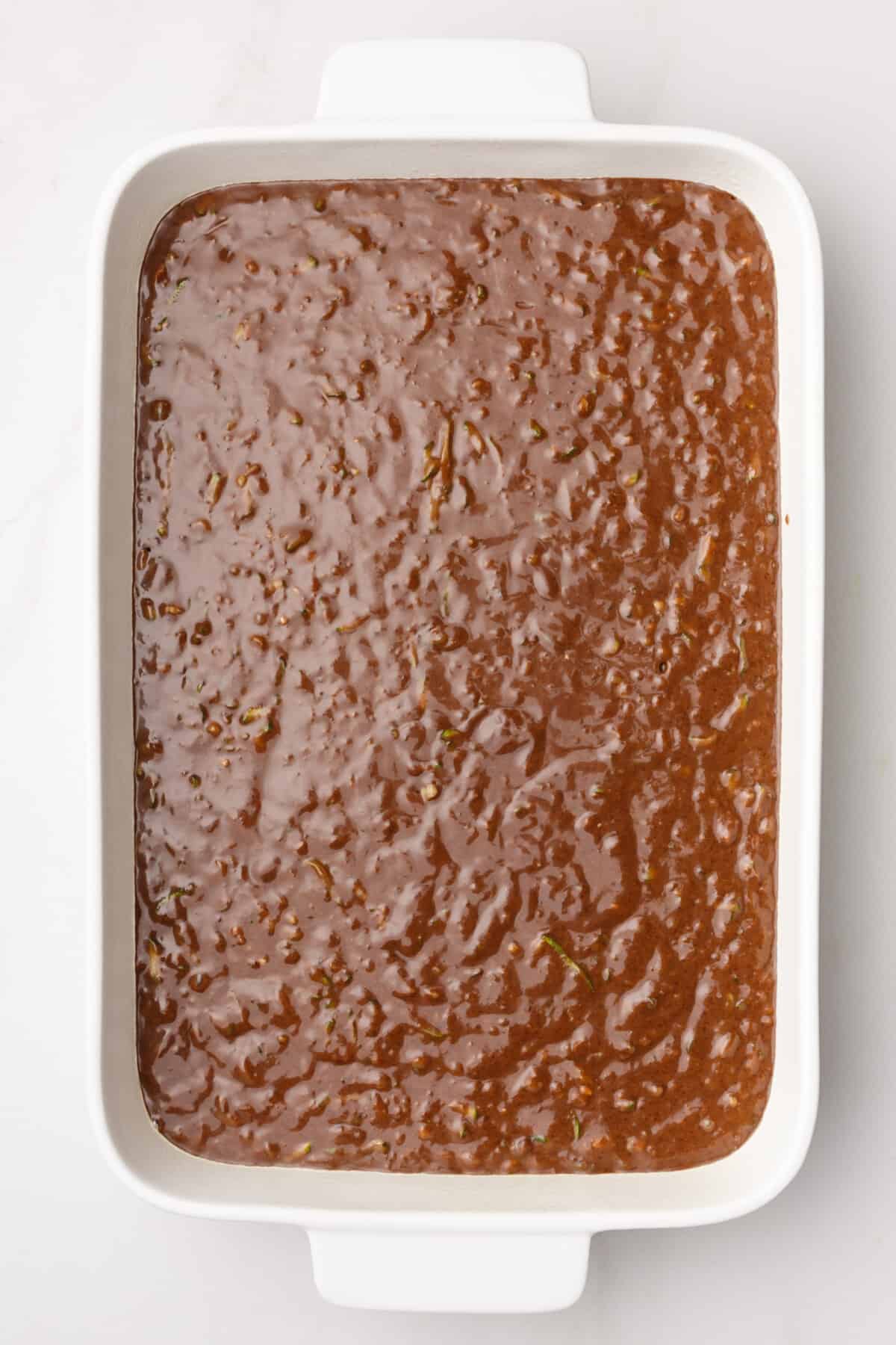 chocolate zucchini cake batter in a 9x13 baking dish.