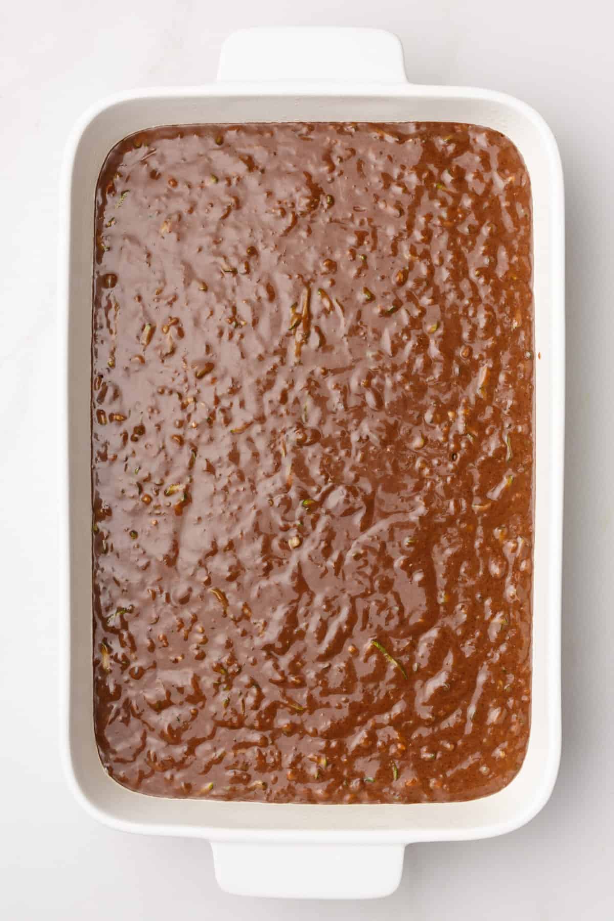 chocolate zucchini cake batter in a 9x13 baking dish