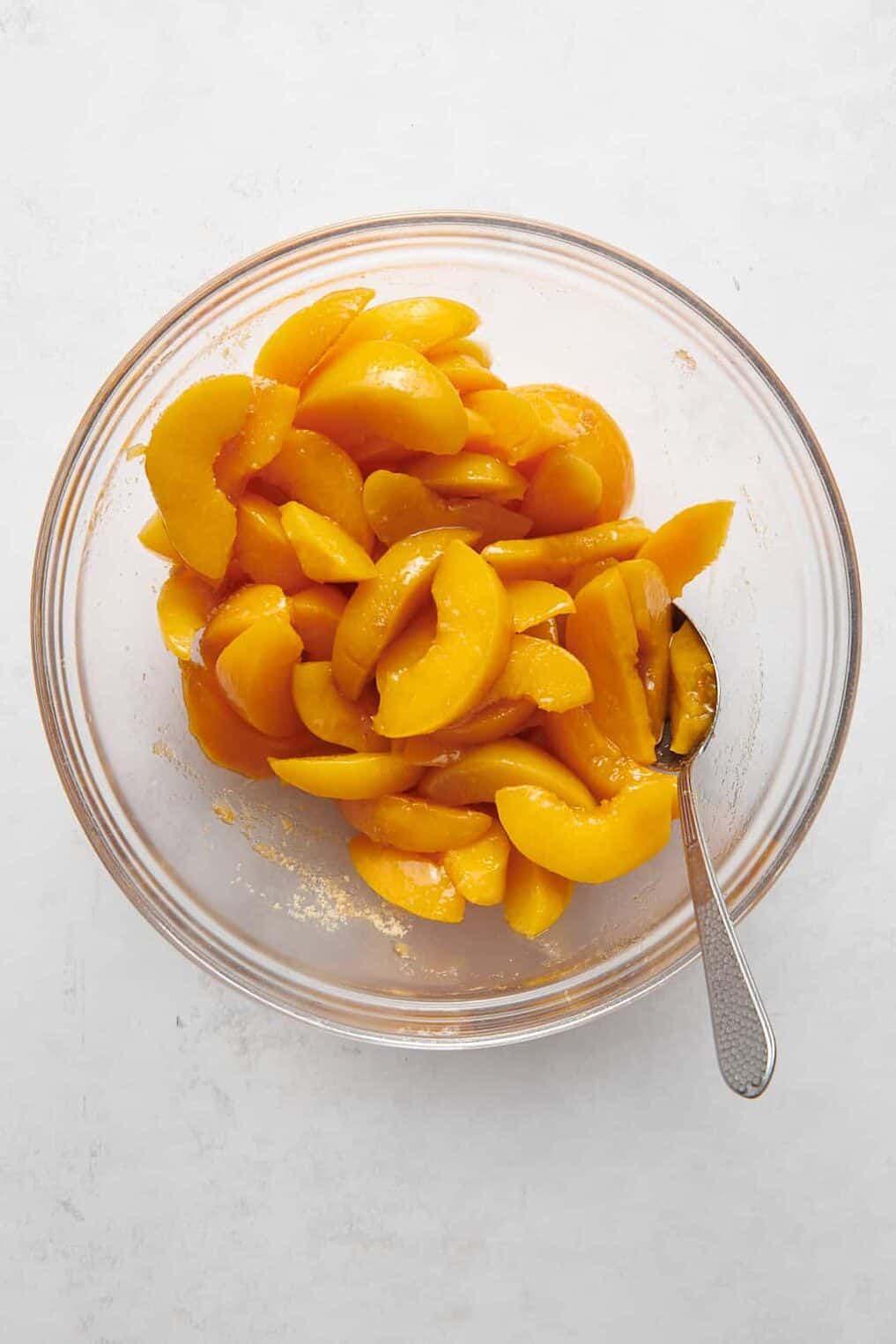 canned sliced peaches in a clear glass bowl