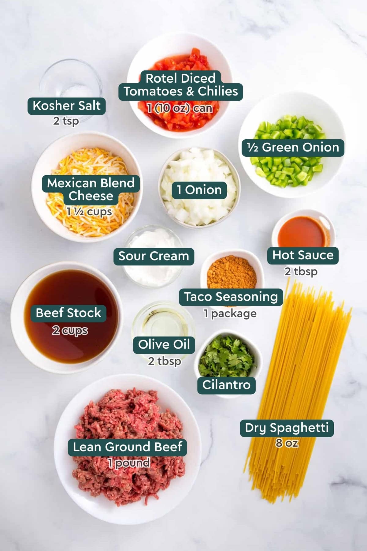 Ingredients for taco spaghetti, including rotel, green onion, onion, cheese, sour cream, hot sauce, taco seasoning, cilantro, oil, stock, spaghetti, and beef.
